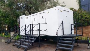 Luxury porta potty trailer next to a park